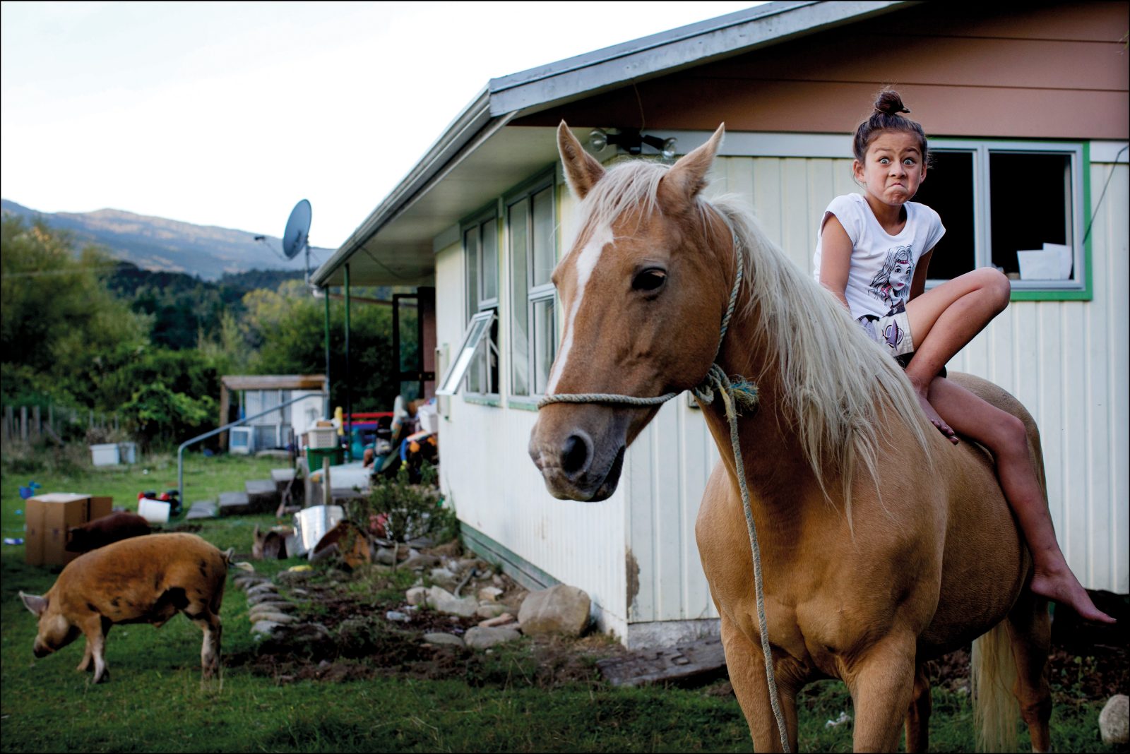 Society and Culture — Winner Photographer David White travelled to the Urewera for a Sunday Star Times photo essay on the historic Treaty settlement with Tūhoe. “The backbone of the story was going to hinge on an interview with tribal elder Tame Iti, but from a photographic point of view, I wanted to concentrate more on the Tūhoe youth,” he says. In the village of Tuai, he came across nine-year-old Te Ataahia Lambert and her family; after a cup of tea, he asked if he could photograph the children while they tended their horses in the fading light. When he raised his camera to photograph Te Ataahia, she widened her eyes and clenched her mouth in a pūkana, a facial expression used for emphasis.